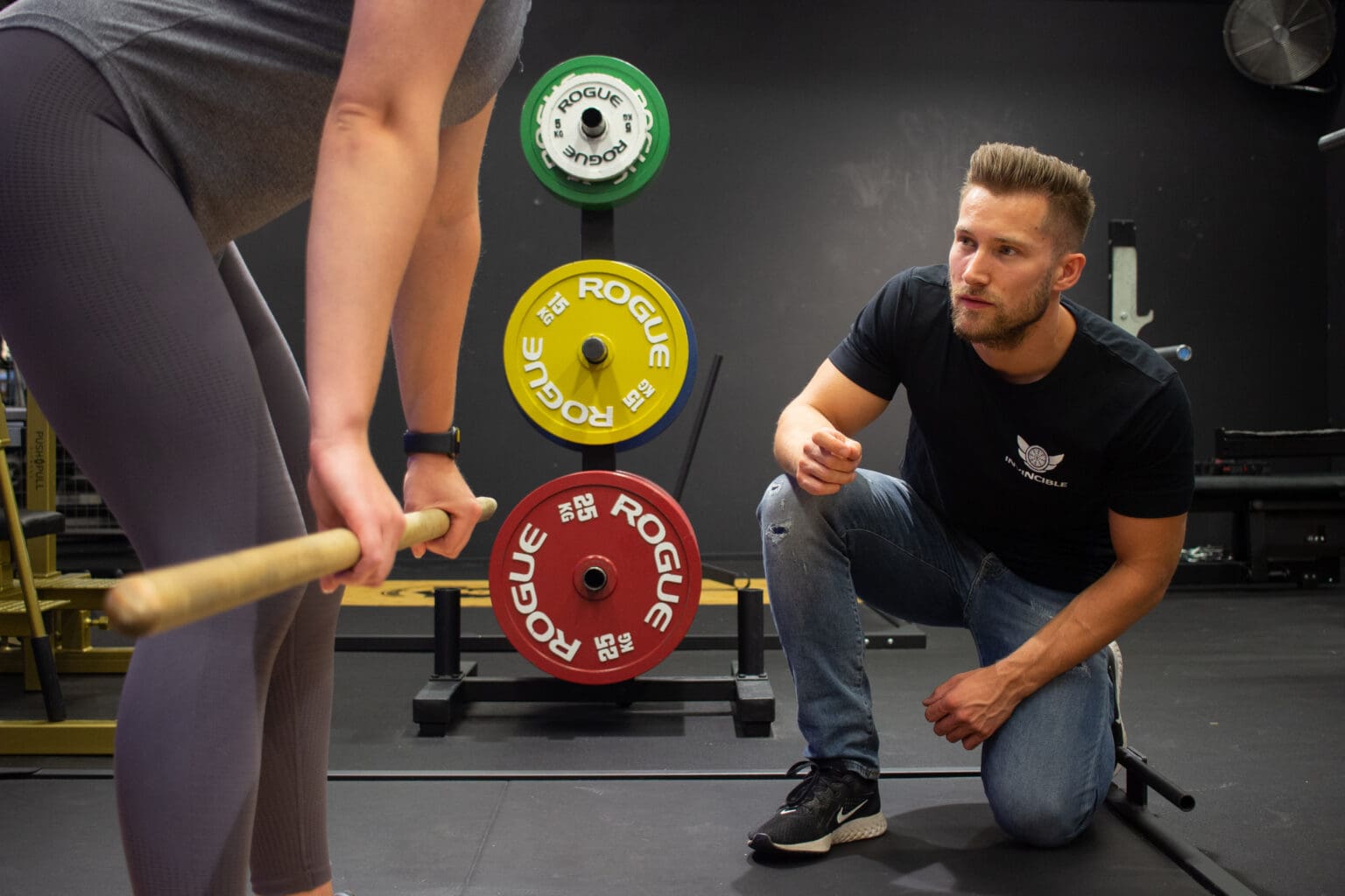 Fysiotherapeut verbeterd de techniek van een patiënt binnen krachttraining